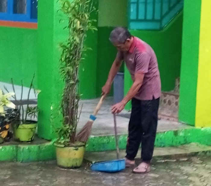 Pak Rici Petugas Kebersihan MTsN 6 Kerinci Tetap Bertugas Saat Hujan