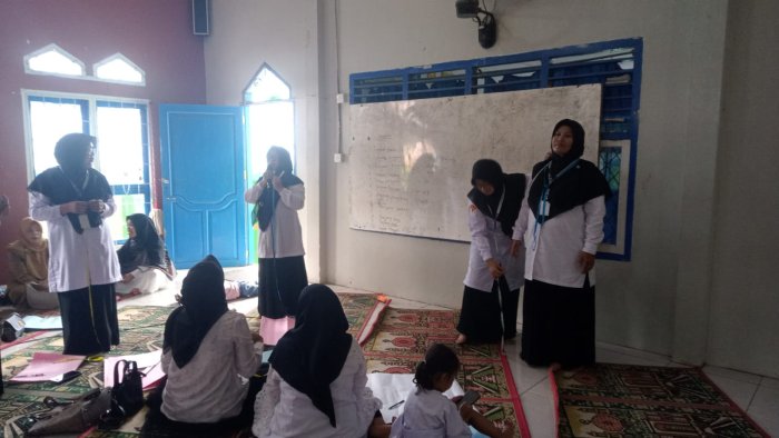 Ibu Harnita, S.Pd.I Didampingi Ibu Jalina Uraikan Langkah-Langkah Pembuatan Pola Baju